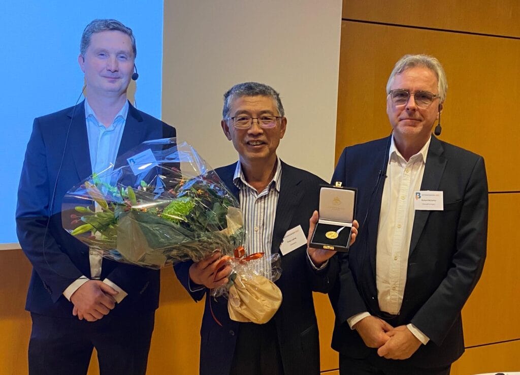 Professor Tang Luping, guldmedaljör 2022, flankerad av t v Henrik Vinell och t h Richard McCarthy.